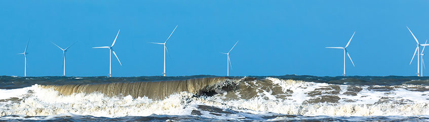 Offshore windmill park in a stormy north sea with spindrift waves